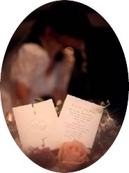 invitation in foreground, couple kissing in background